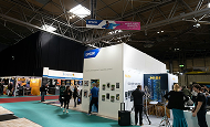 Visitors at exhibition stands in a trade fair hall