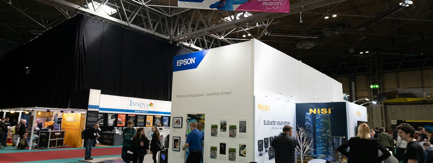 Visitors meeting at exhibition stands inside a trade fair hall